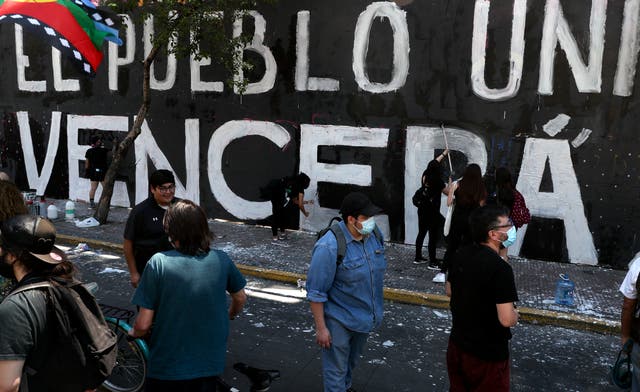 <p>Manifestantes pintan una pared mientras conmemoran el aniversario del estallido social de 2019 en protesta a un incremento en las tarifas del metro en Santiago de Chile el domingo 28 de octubre de 2020.&nbsp;</p>