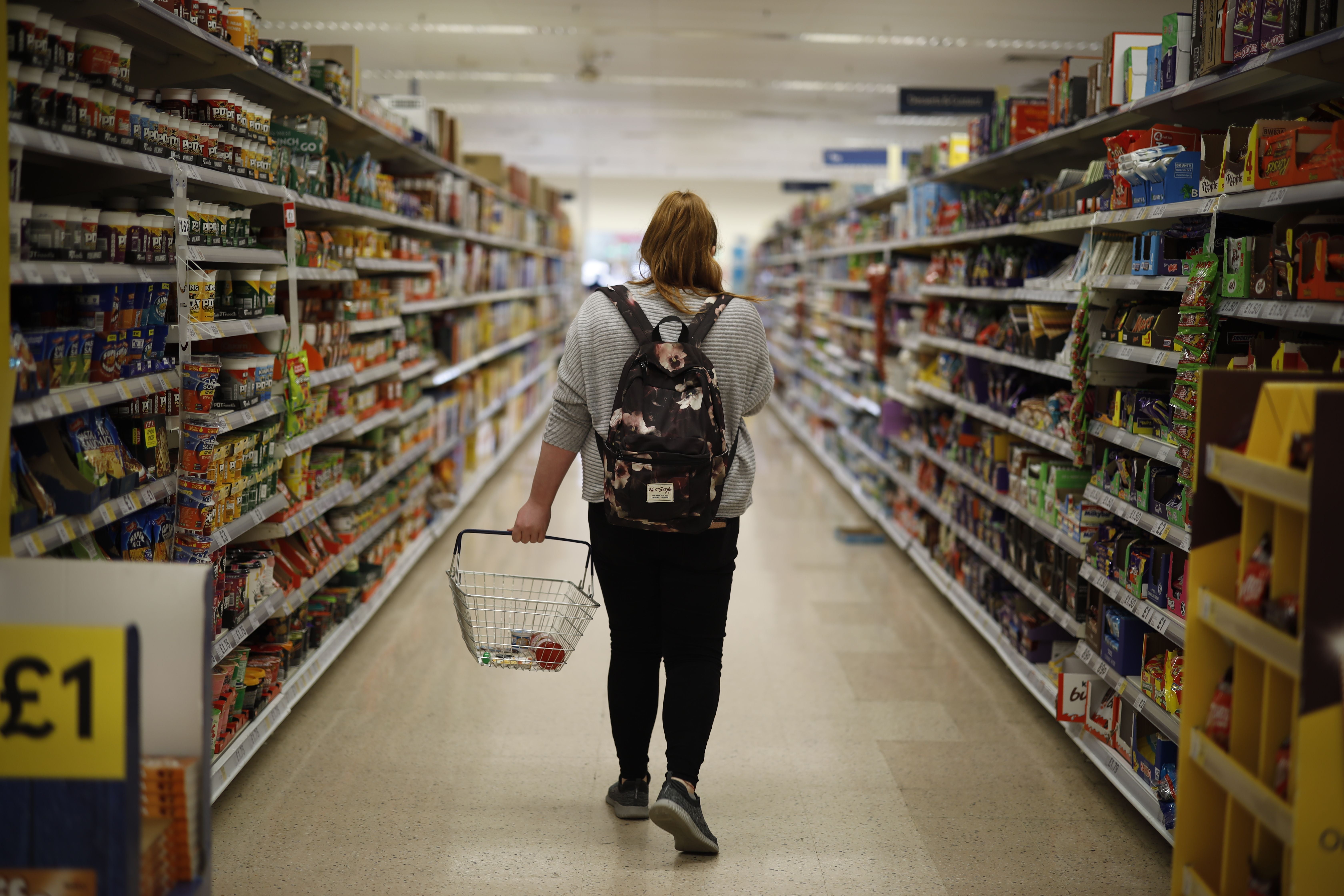 A shopper browses an aisle for groceries at a Tesco Superstore in south London