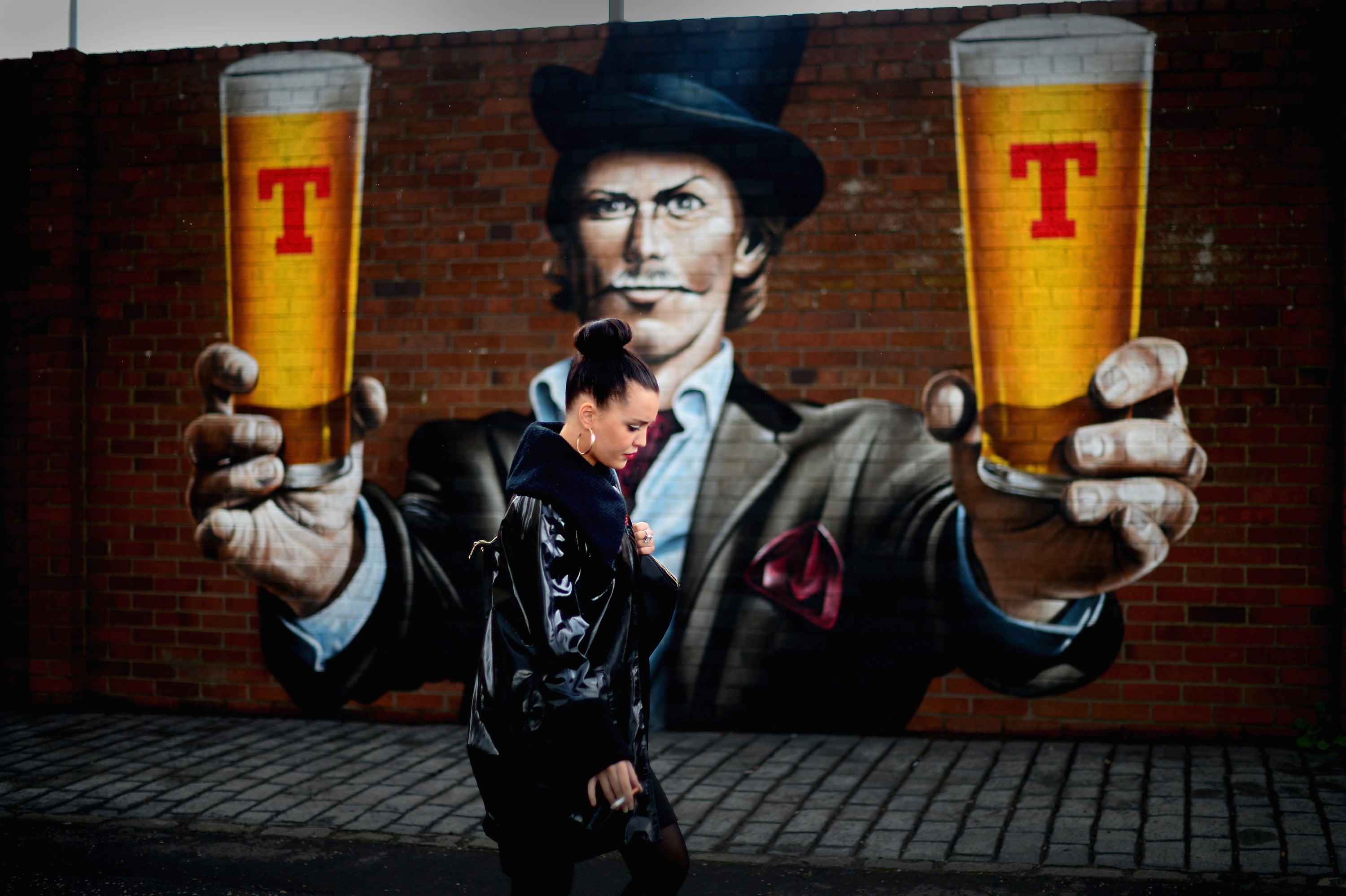 File image: A woman walks past stencilling on a wall in Glasgow, Scotland.
