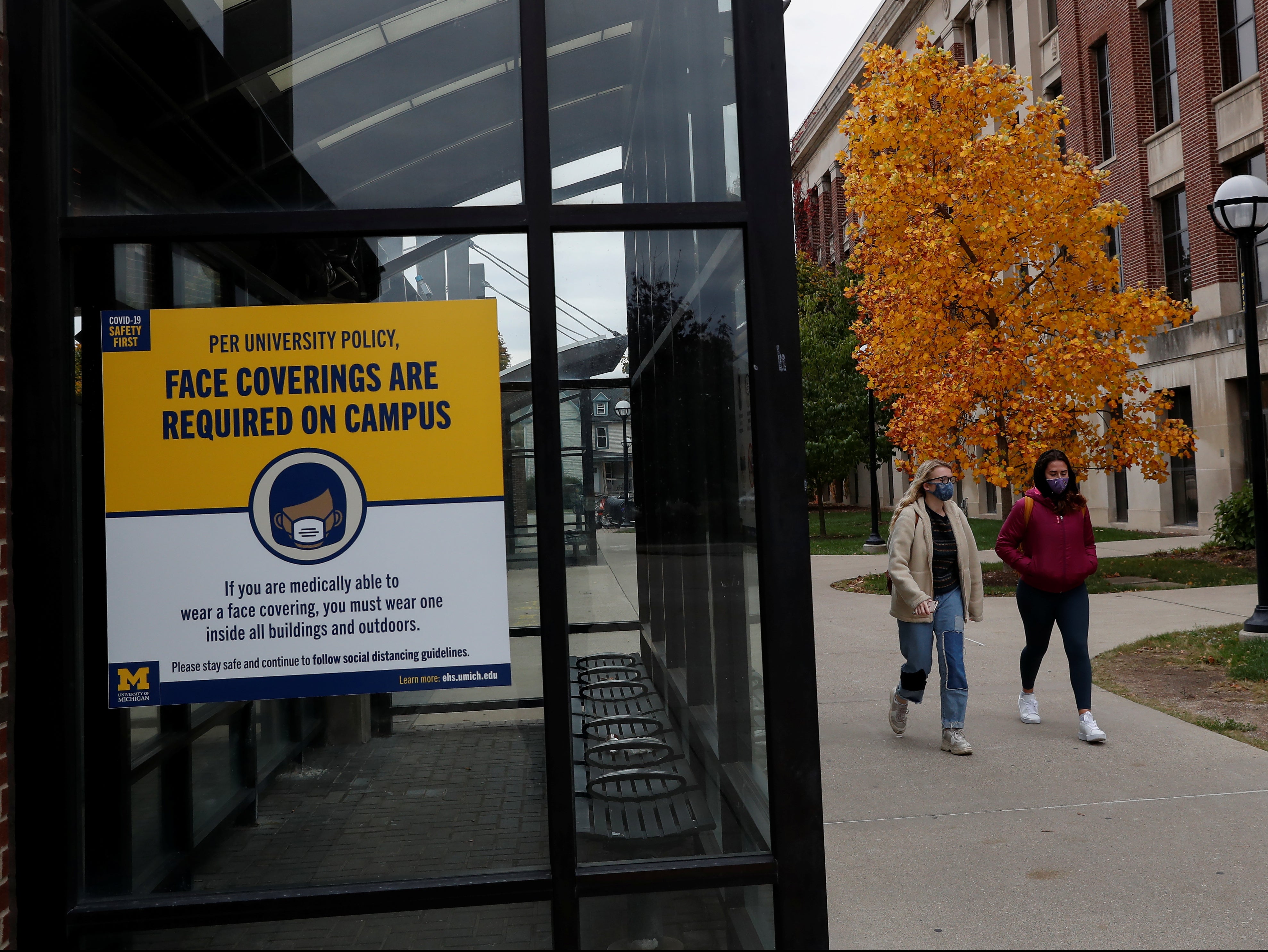 Women with protective face masks walk on the University of Michigan campus, where state health officials in Michigan issued a stay-in-place order for undergraduate students, in Ann Arbor, Michigan, US 26 October, 2020