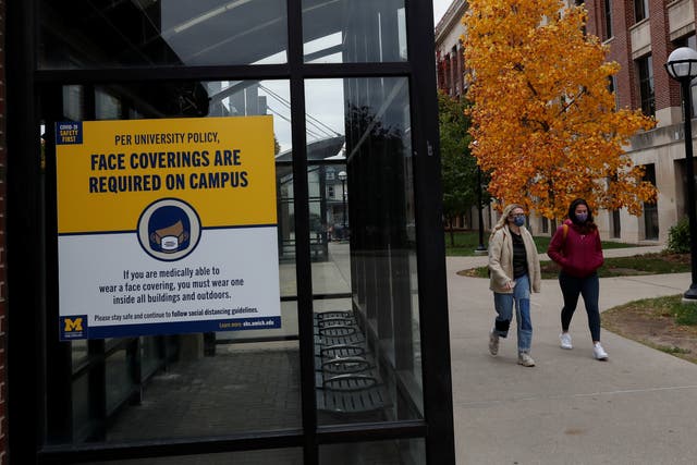 Women with protective face masks walk on the University of Michigan campus, where state health officials in Michigan issued a stay-in-place order for undergraduate students, in Ann Arbor, Michigan, US 26 October, 2020