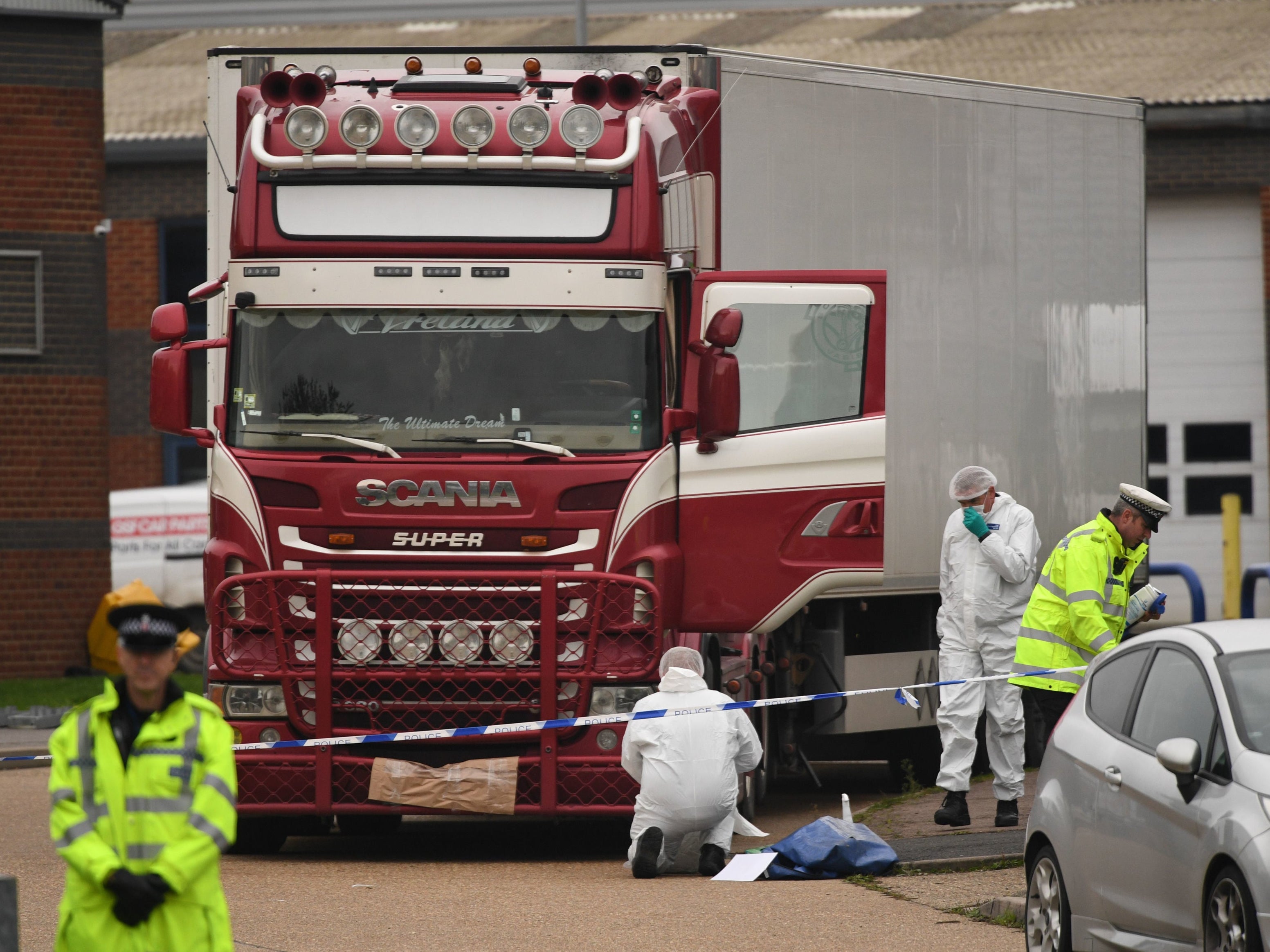 Police and forensic officers examine the lorry at Waterglade Industrial Park in Grays, Essex