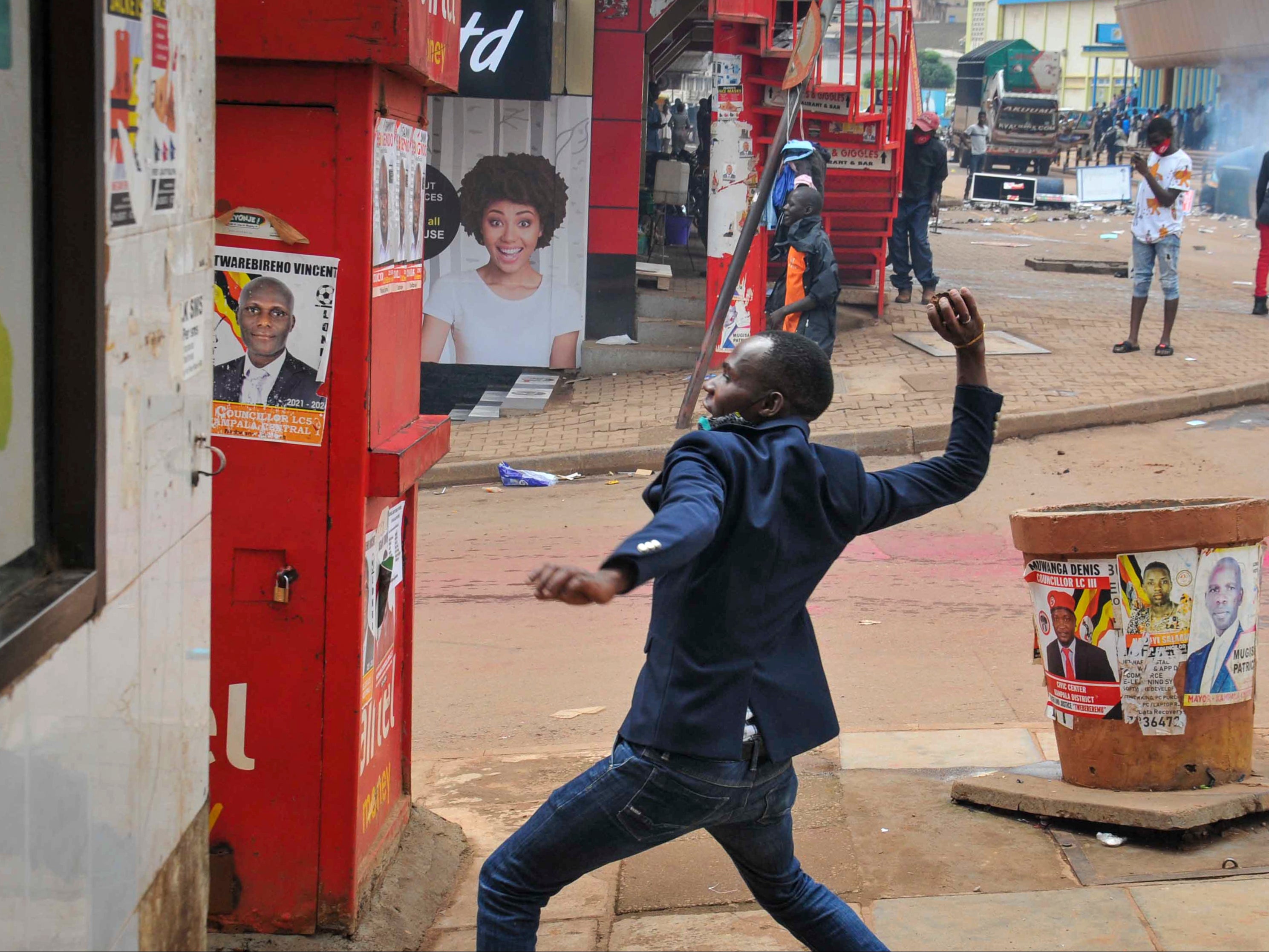 A man prepares to throw a rock during clashes between security forces and protesters supporting Bobi Wine, in Kampala, Uganda