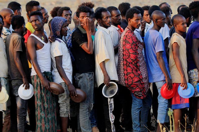 Ethiopian men who fled war in Tigray region queue for food rations at the Um-Rakoba camp