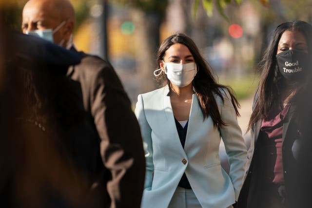Rep Alexandria Ocasio-Cortez, center, arrives for an event with Rep.-elect Cori Bush, right on Thursday, 19 November 2020, outside the Democratic National Committee