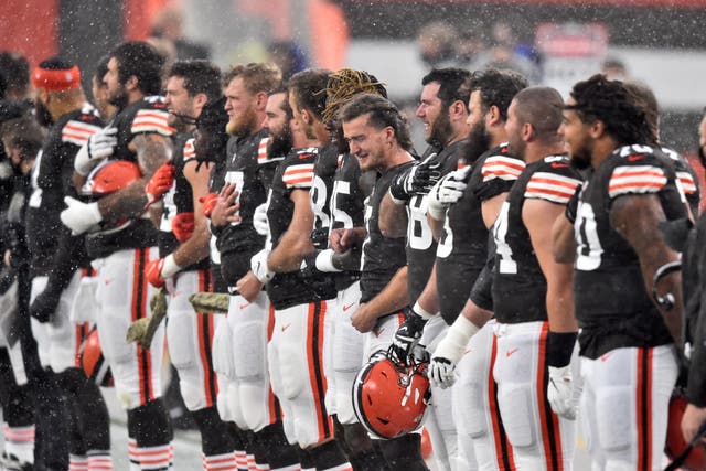 <p>Jugadores de los Browns de Cleveland escuchan el himno nacional bajo la lluvia antes del partido frente a los Texans de Houston, el domingo 15 de noviembre de 2020, en Cleveland.</p>