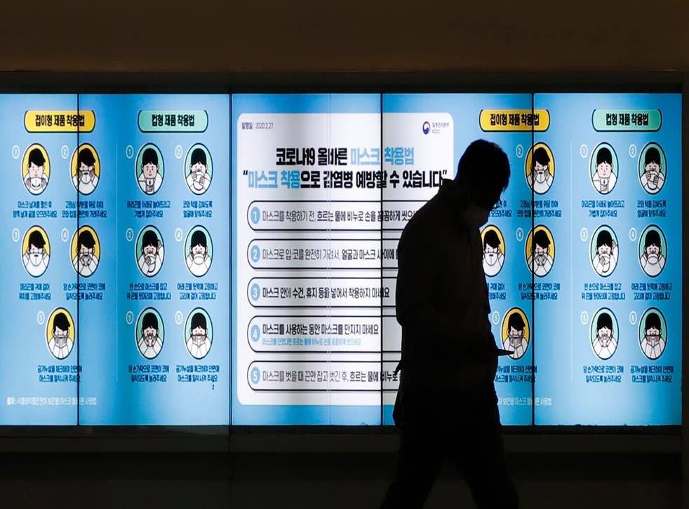 <p>Un hombre con mascarilla pasa por delante de una pantalla que muestra las medidas de precaución contra el coronavirus, en Seúl, Corea del Sur, el 20 de noviembre de 2020. El letrero dice "Como llevar mascarilla".</p>
