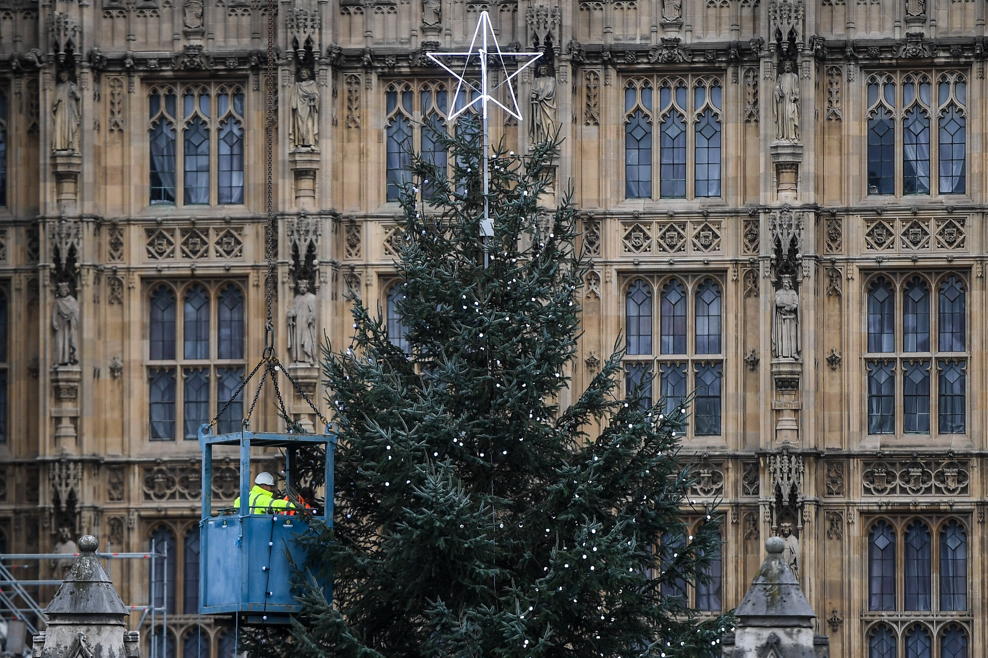 Workers add lights to the tree outside the Commons on Saturday