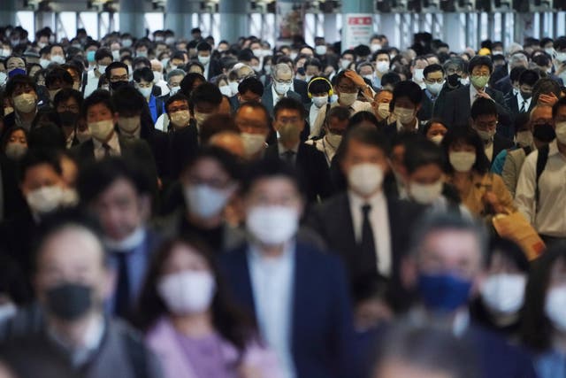 <p>Centenares de pasajeros con mascarillas caminan por el pasillo de una estación de transporte colectivo durante una hora pico en Tokio el viernes 20 de noviembre de 2020.</p>