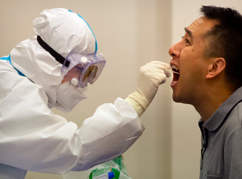 <p>Personal médico le realiza una prueba de coronavirus a un hombre en Hainan, China, el 22 de noviembre de 2020.</p>