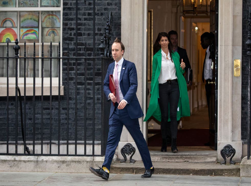 Matt Hancock leaves 10 Downing Street after the daily press briefing in May, with Gina Colandangelo in the green coat