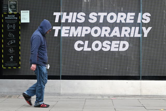 A man walks past a temporarily-closed clothing store on Oxford Street, London