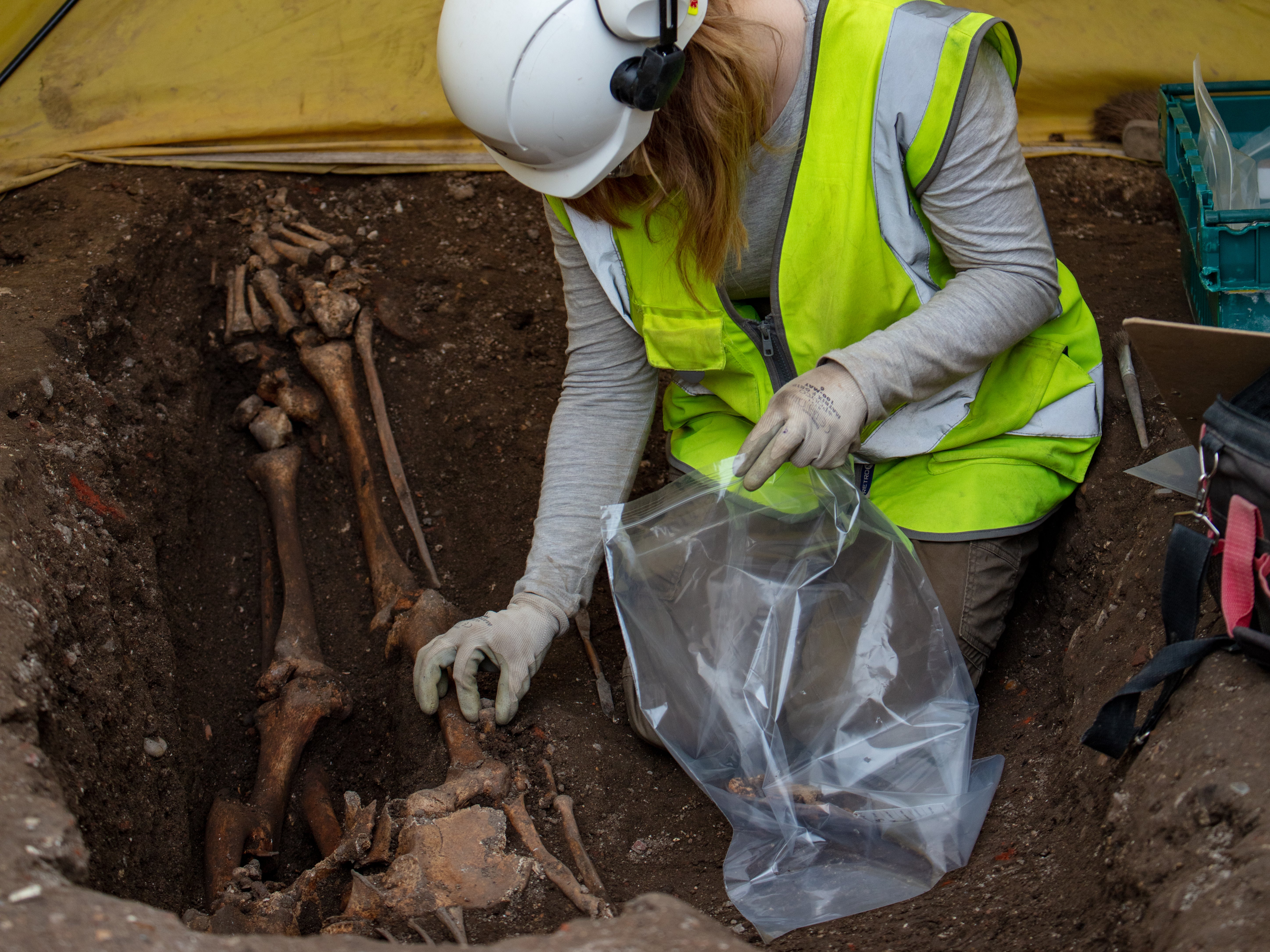 An archaeologist carefully removes the bones from this burial