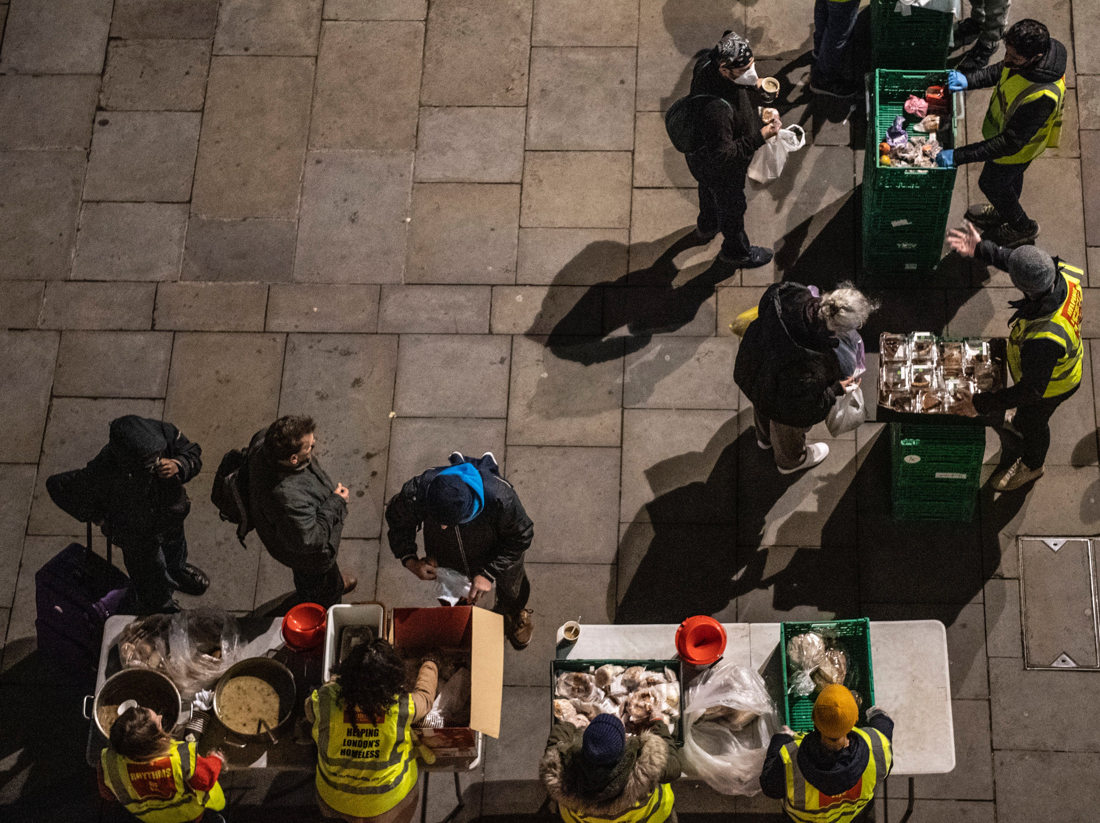 Homeless people collect donated food provided by charity, Rhythms of life near Trafalgar Square, London