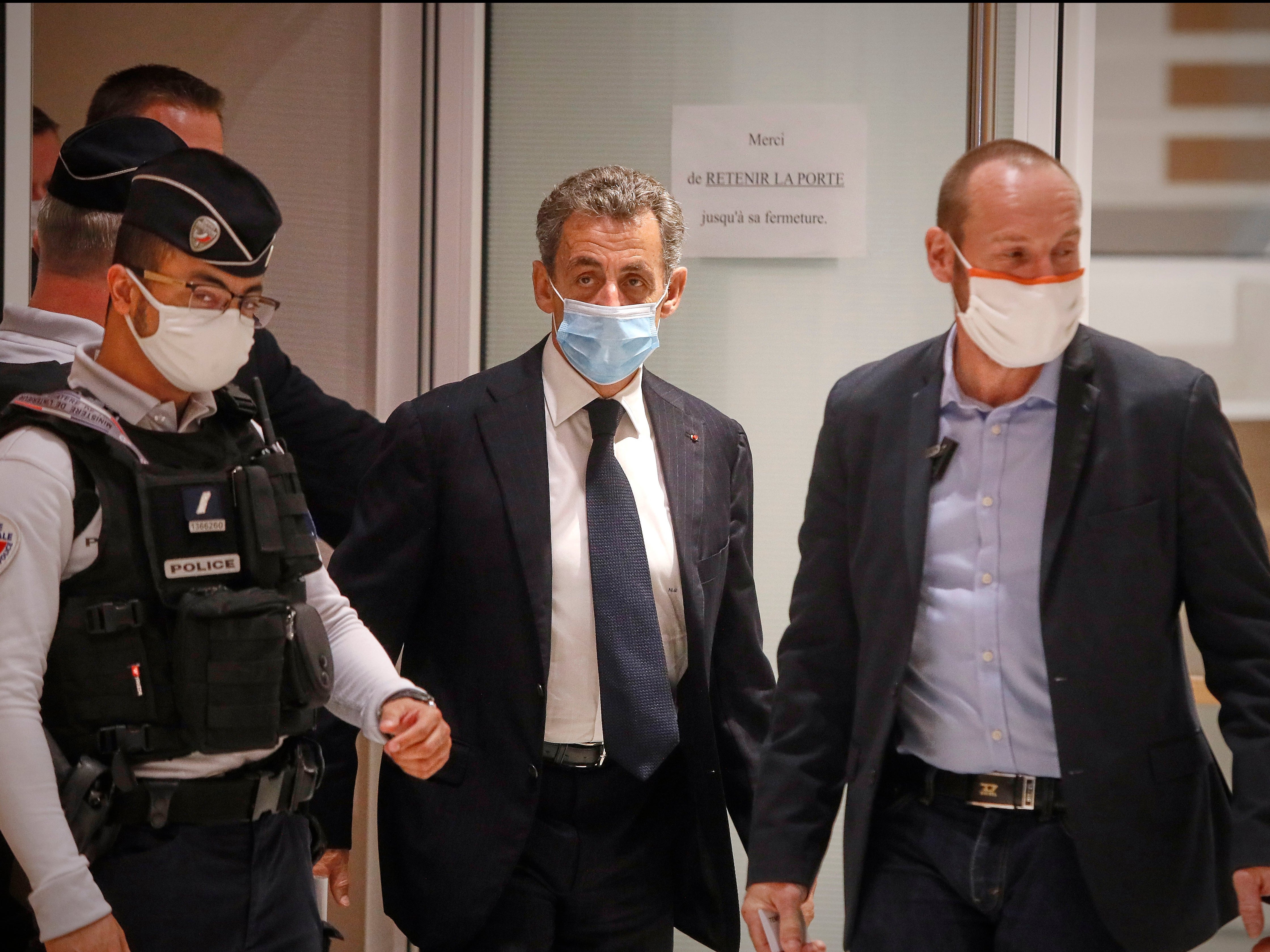 Former French President Nicolas Sarkozy leaves court after the opening of his trial for corruption and influence pedalling