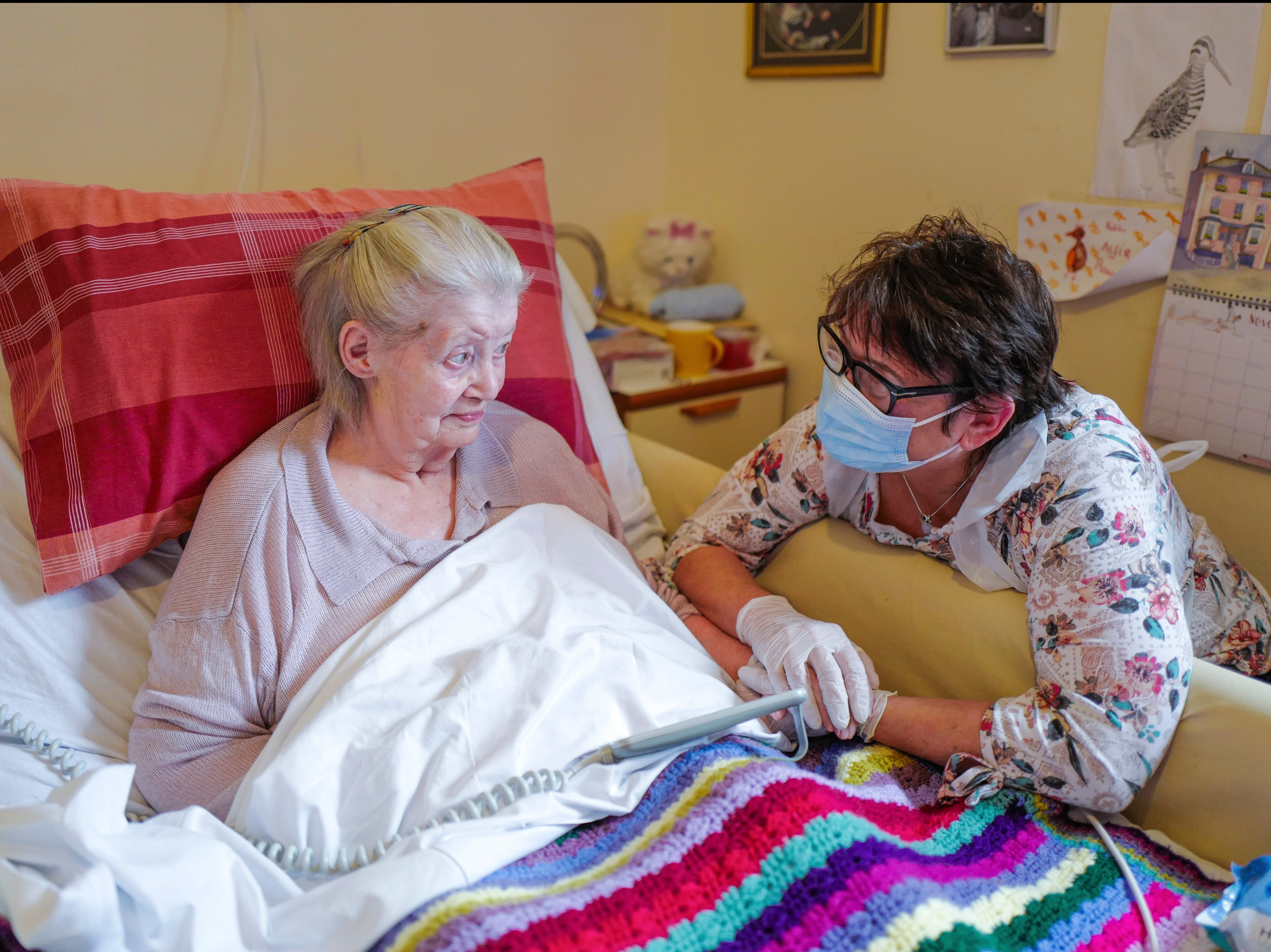 Care home resident Dot Hendy holds her daughter Louise’s hand last week for the first time since March