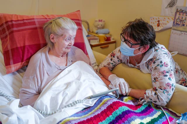 Care home resident Dot Hendy holds her daughter Louise’s hand last week for the first time since March