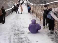 Tourist slides down Great Wall of China in icy conditions