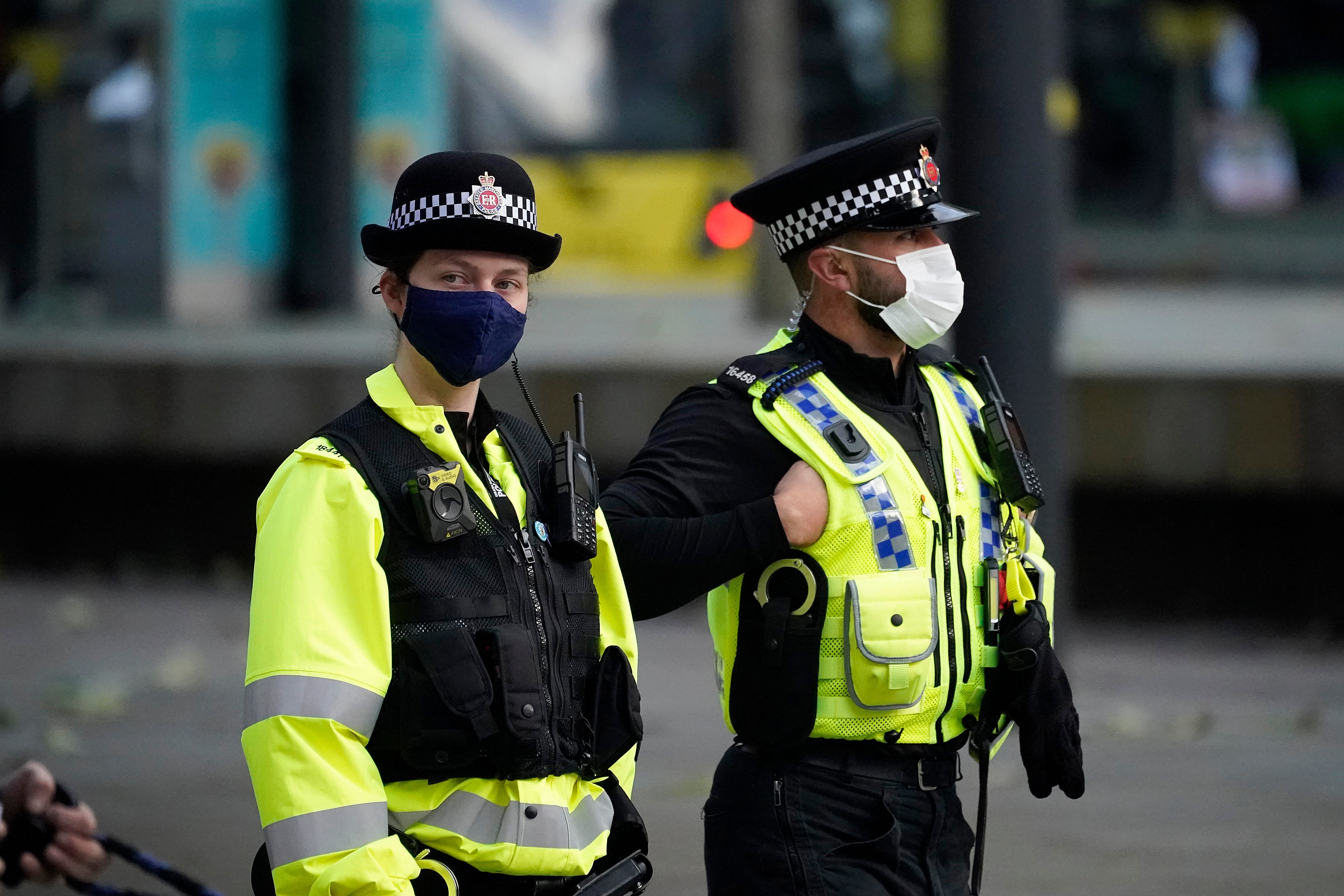 Police officers wear face masks as they patrol Manchester city centre