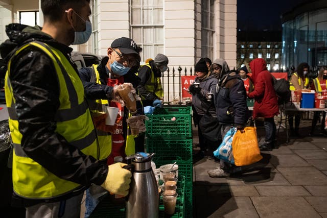 <p>Homeless people collect donated food provided by the Rhythms of Life charity near Trafalgar Square, London</p>