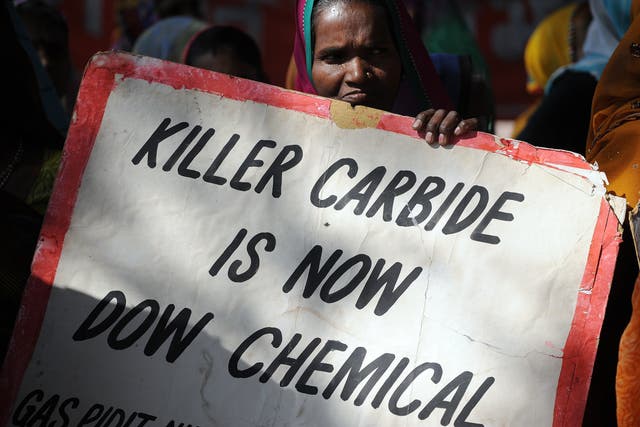 <p>A Bhopal Gas disaster survivor holds a placard during a protest rally in Bhopal on December 2, 2014. </p>
