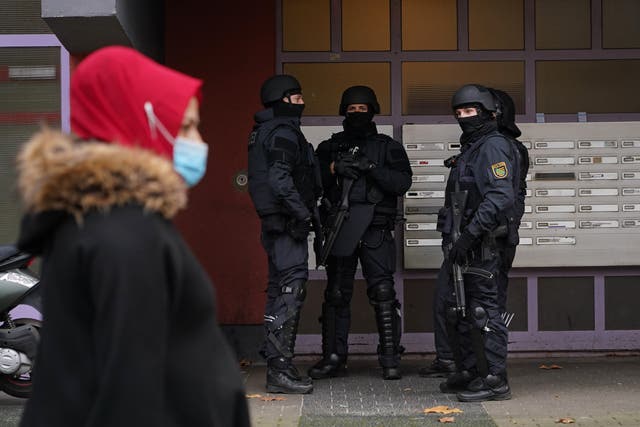 <p>Heavily-armed police standing outside an apartment building in Kreuzberg district</p>