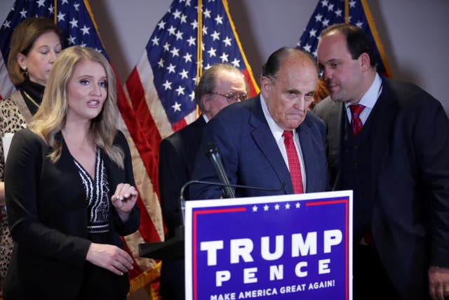 <p>Trump campaign advisor Boris Epshteyn whispers to Rudy Giuliani during a press conference at the Republican National Committee headquarters in Washington DC on 19 November.</p>