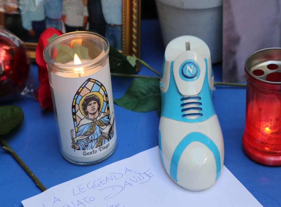<p>Una vela que dice "Santo Diego" y un zapato con el logo del club de fútbol SSC Napoli.</p>