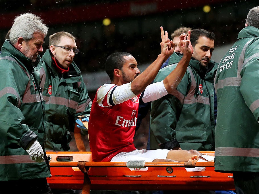 Theo Walcott is taken off on a stretcher during the North London derby in 2014