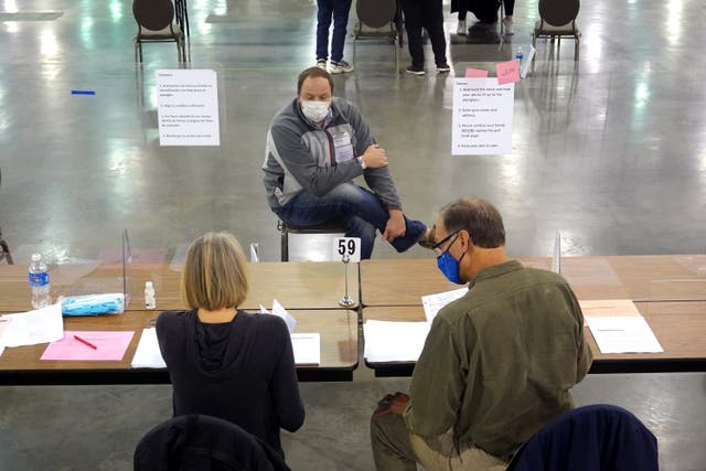 An election observer watches Wisconsin officials perform a recount of votes.