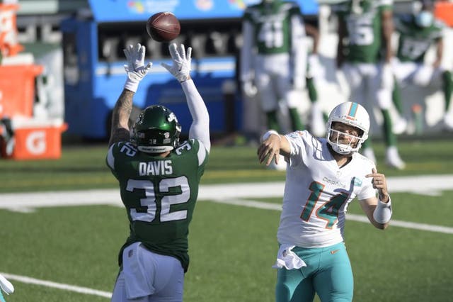 Ashtyn Davis (32), izquierda, de los Jets de Nueva York, trata de bloquear un pase del quarterback Ryan Fitzpatrick, de los Dolphins de Miami, en el duelo de NFL del domingo 29 de noviembre de 2020, en East Rutherford, Nueva Jersey. 