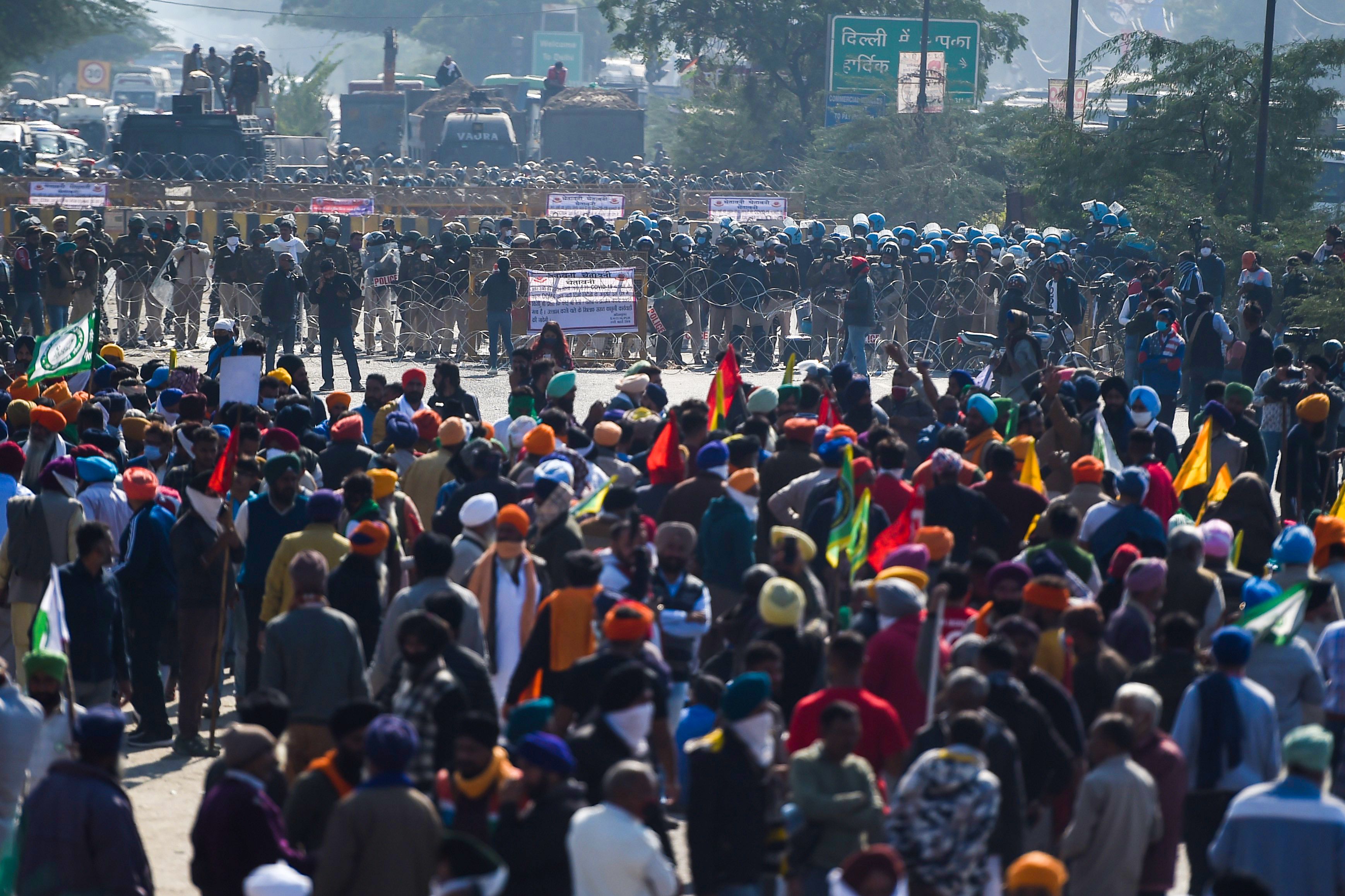 Police block a street to impede farmers from marching to New Delhi to protest against the central government's recent agricultural reforms at the Delhi-Haryana border in Kundli on November 27, 2020.