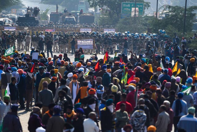 <p>Police block a street to impede farmers from marching to New Delhi to protest against the central government's recent agricultural reforms at the Delhi-Haryana border in Kundli on November 27, 2020.</p>