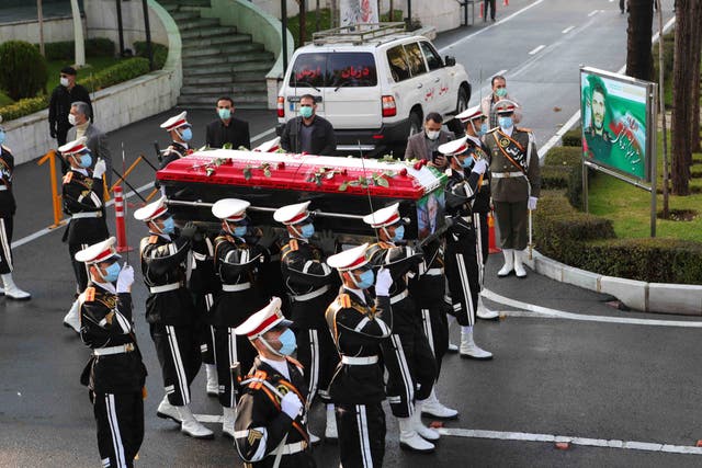 <p>Iranian military personnel carrying the flag-draped coffin of nuclear scientist Mohsen Fakhrizadeh</p>