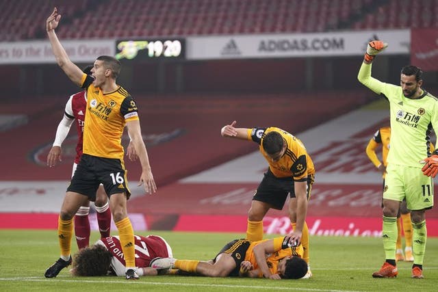 Los jugadores piden auxilio luego del choque de cabezas entre David Luiz de Arsenal y el mexicano de los Wolves. 