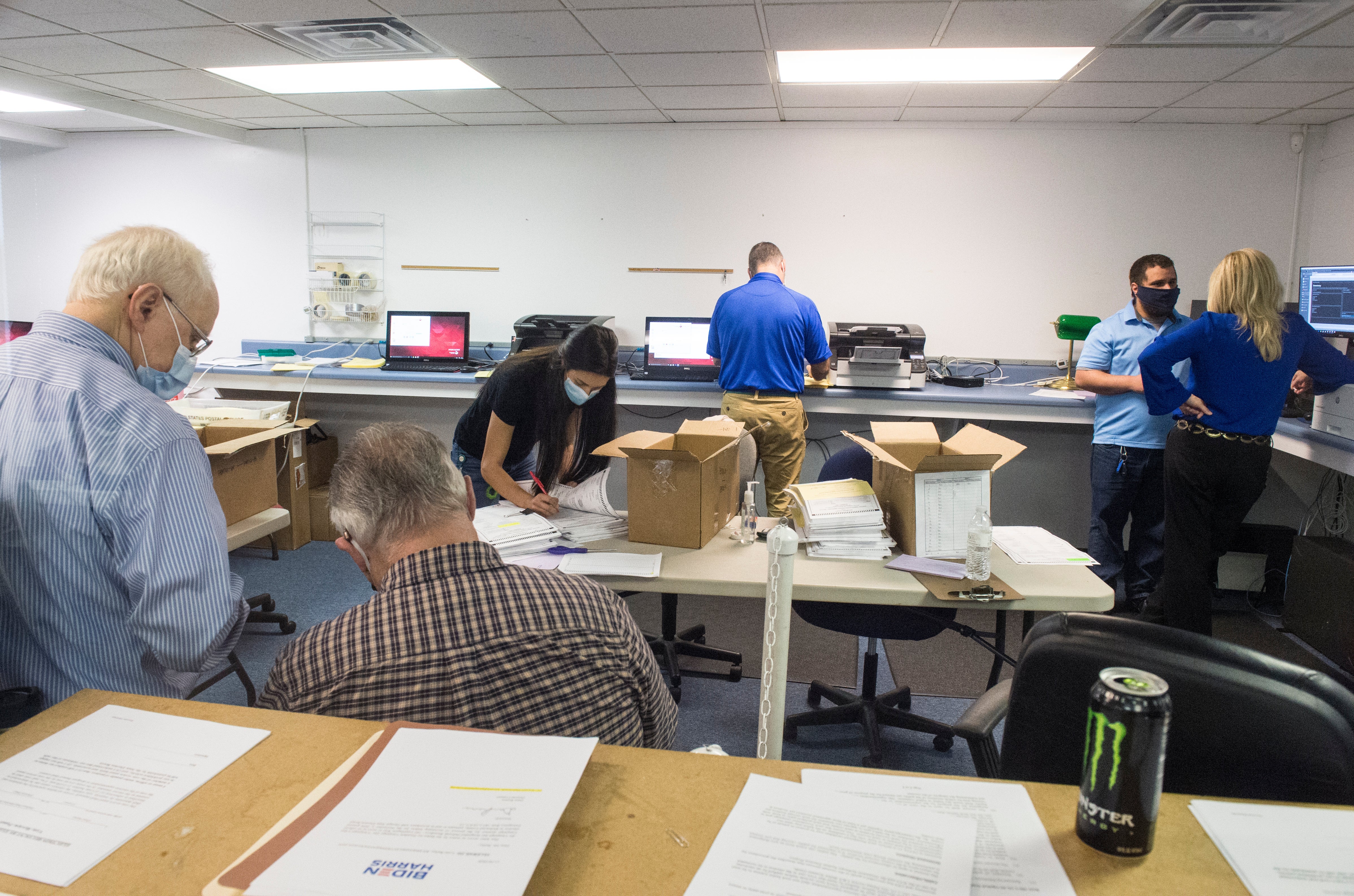 Republican observers watch election officials counting absentee ballots during the Georgia presidential election recount
