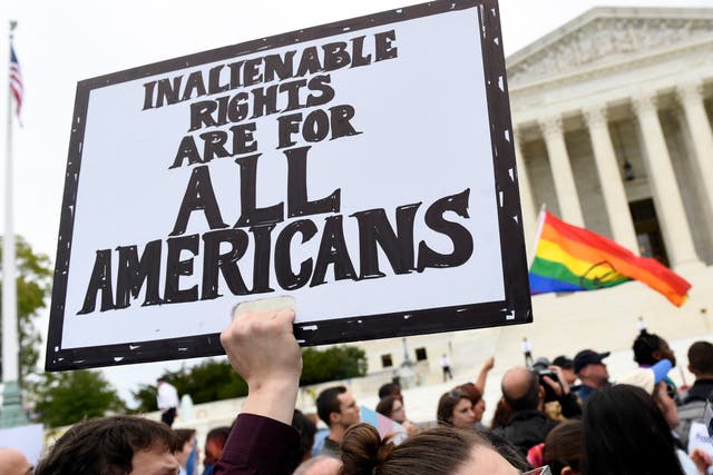 In this 8 October 2019, file photo, protesters gather outside the Supreme Court in Washington where the Supreme Court is hearing arguments in the first case of LGBT+ rights since the retirement of Supreme Court Justice Anthony Kennedy