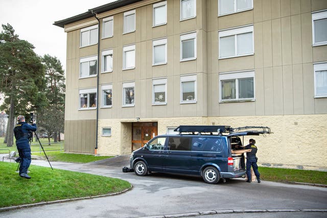 <p>Police at the apartment block in Stockholm where a woman allegedly locked up her son for three decades</p>
