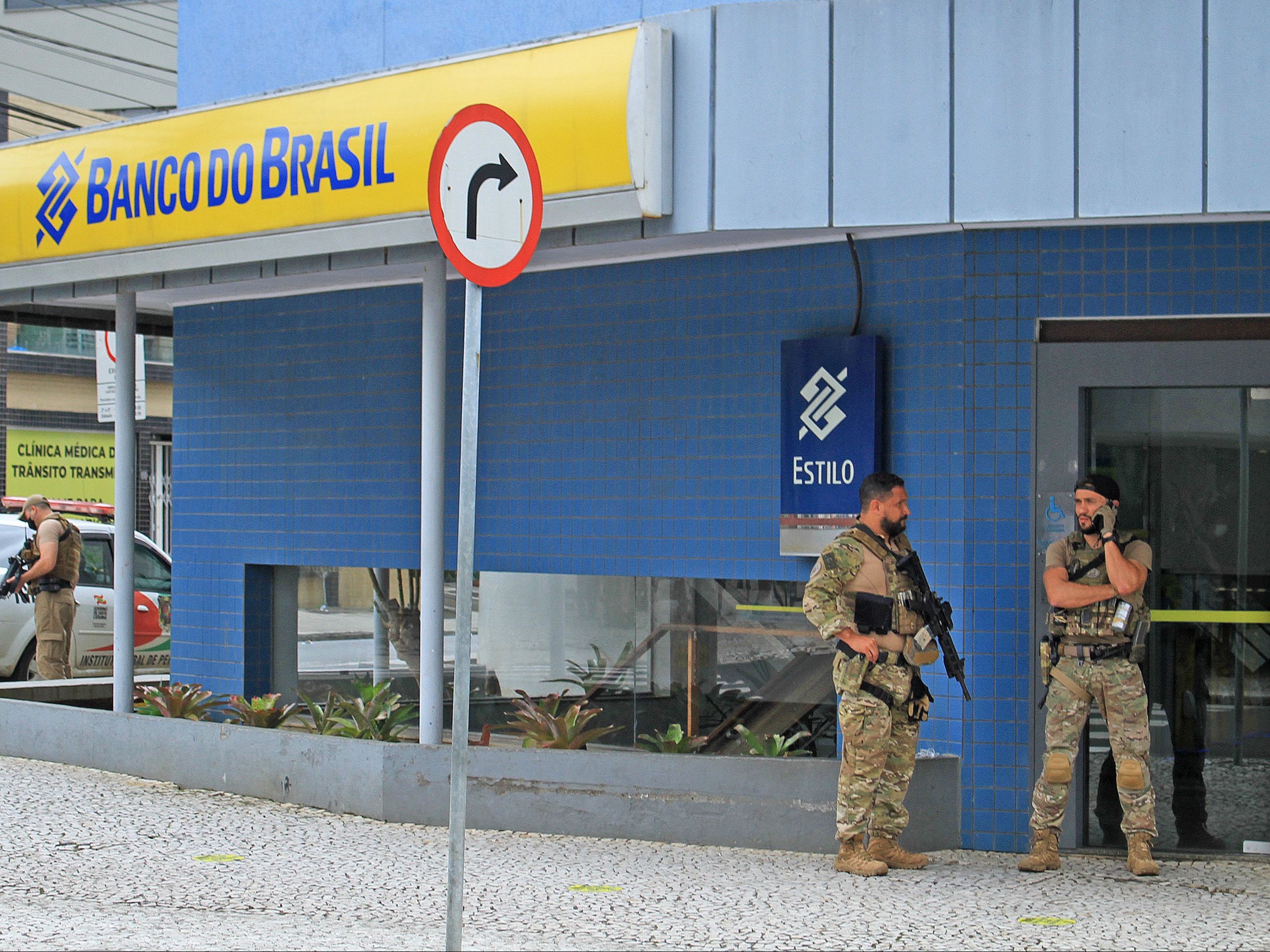 Police officers stand guard outside the bank which robbers attacked just after midnight, in the city of Criciuma