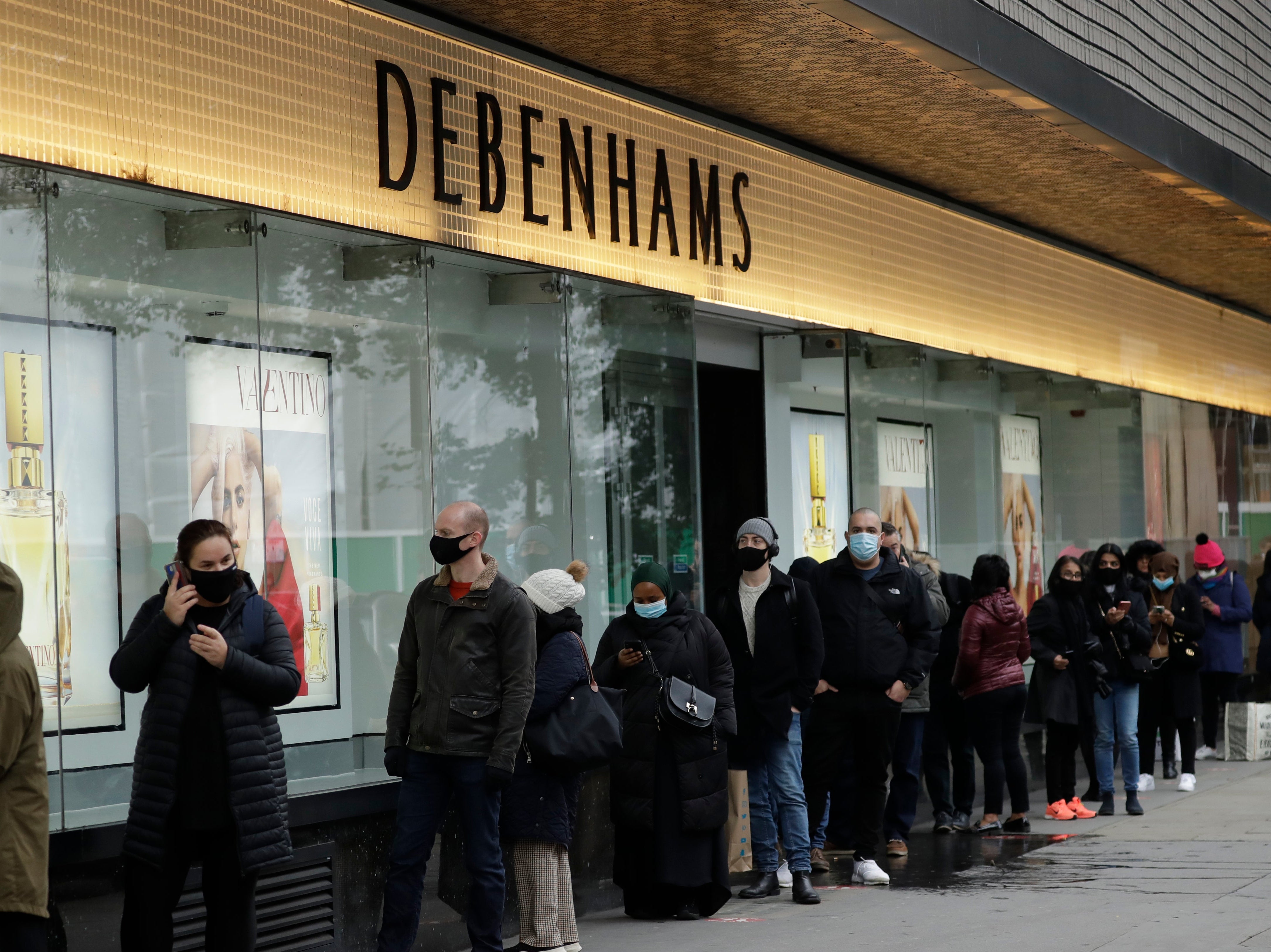 People queue up waiting for the Debenhams department store, which is expected to close down, in London’s Oxford Street