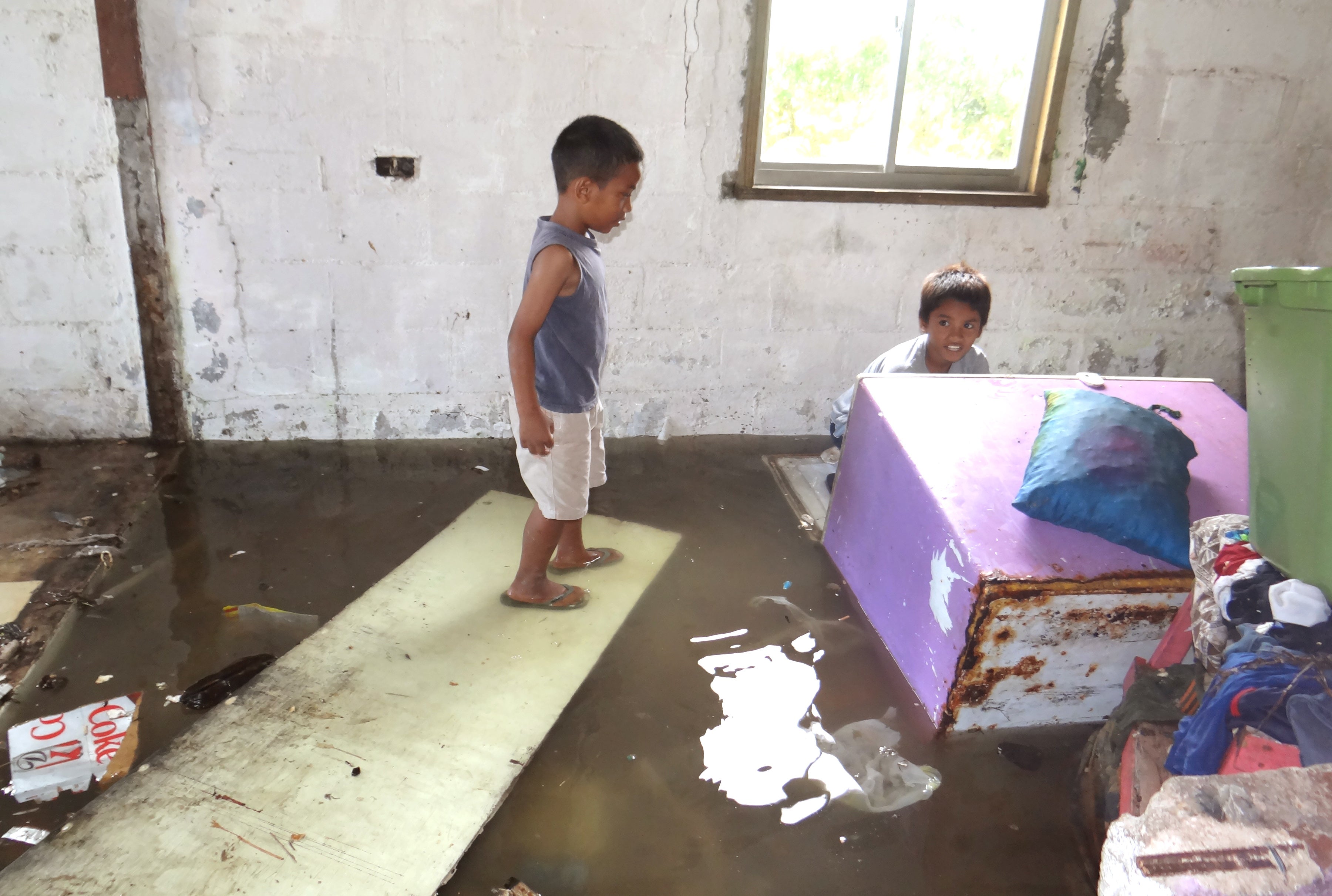 Two children look at the flooding in a house on the Marshall Islands in 2014. The low-lying Pacific nation is among one of the most vulnerable to sea-level rise from climate change&nbsp;