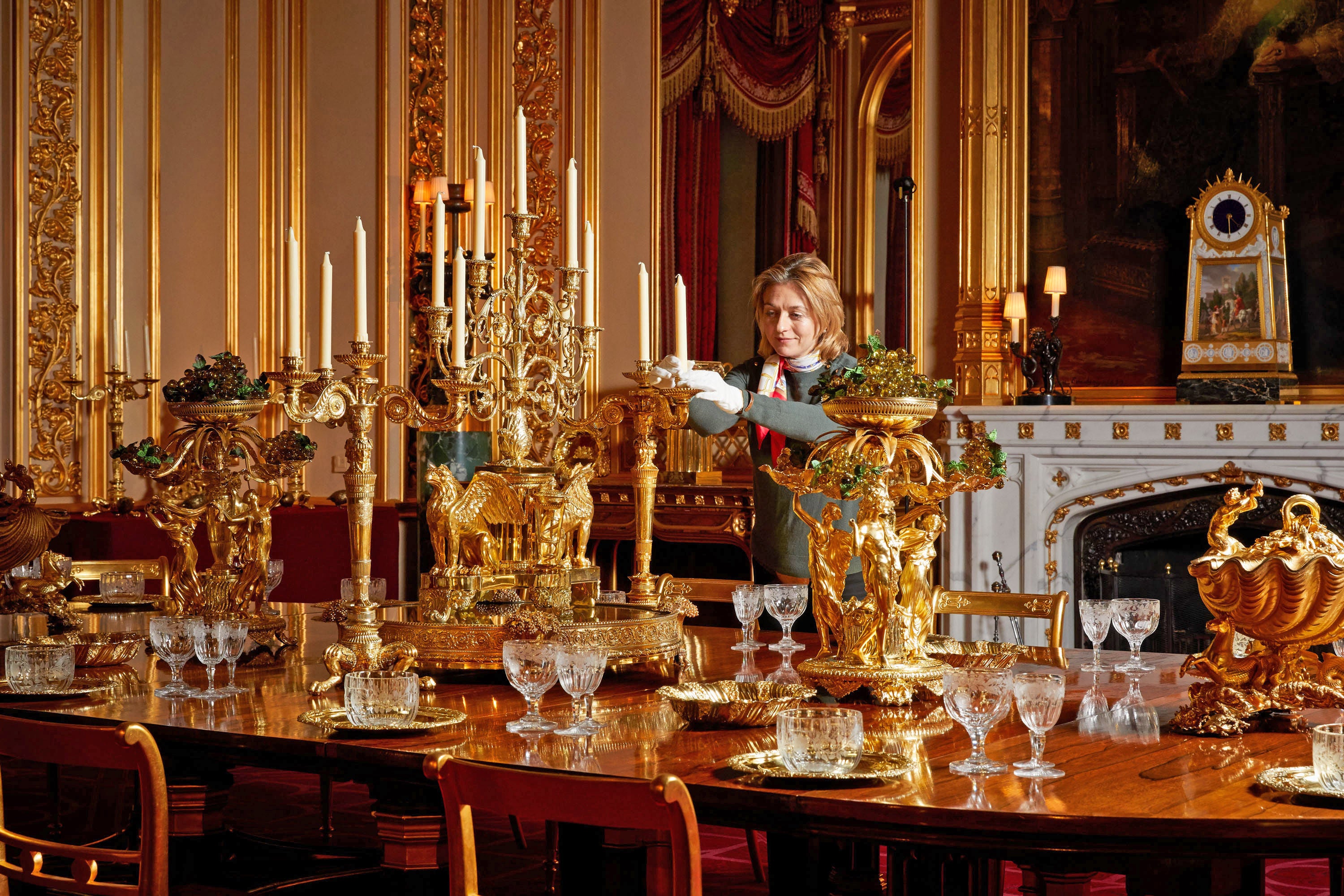 A Royal Collection Trust curator puts the finishing touches on a special display of the silver-gilt Grand Service in the State Dining Room at Windsor Castle