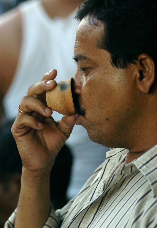 <p>File: An Indian man drinks tea from an earthenware cup</p>