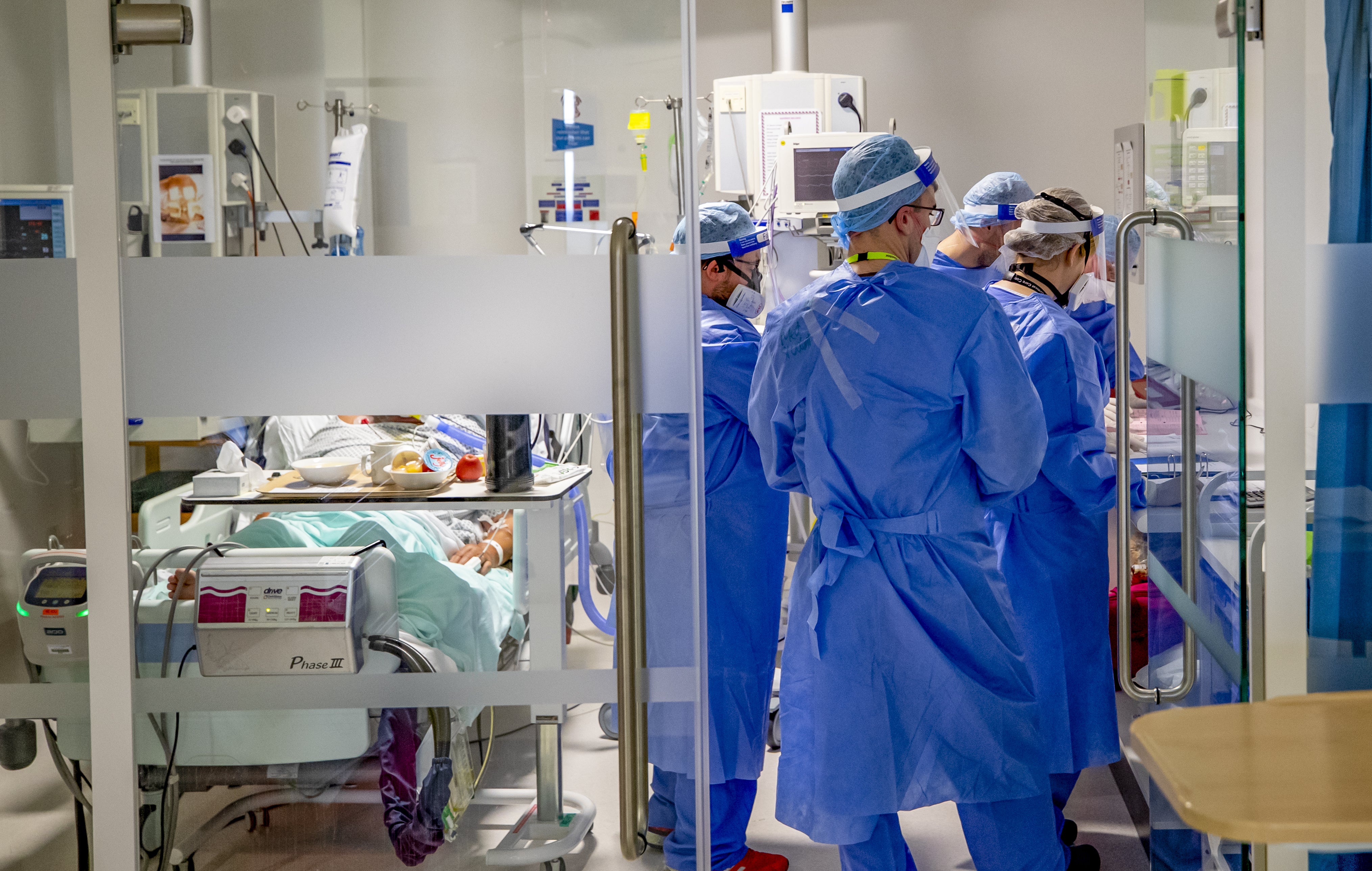 Health workers in full PPE tend to a patient in intensive care at Whiston Hospital, Merseyside&nbsp;