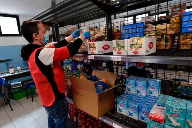 <p>Volunteer stacks shelves at a food bank in Milan</p>