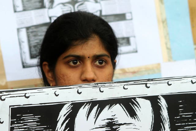 File image: An activist supporting the group Anonymous holds a poster as they protest against the Indian Government's increasingly restrictive regulation of the internet outside a shopping mall in Bangalore on June 9, 2012.