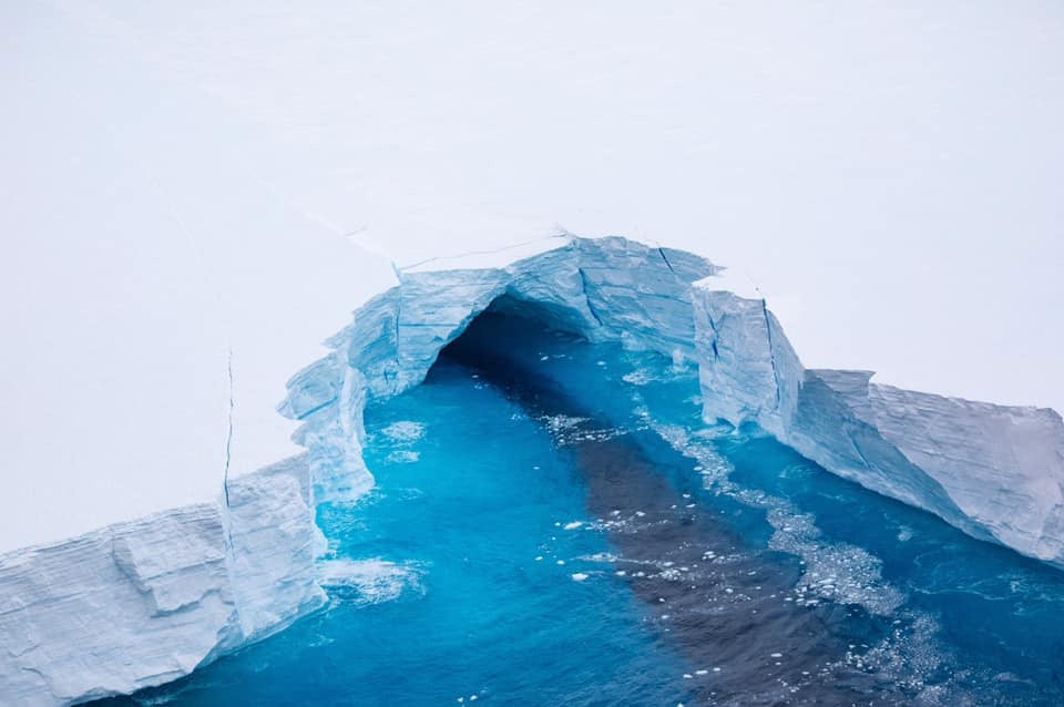 Tunnels and deep fissures run through the iceberg under surface level