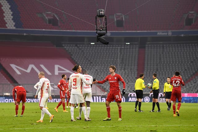 MÚNICH, ALEMANIA - DICIEMBRE 05: Thomas Mueller del FC Bayern Munich da la mano a Yussuf Poulsen del RB Leipzig después del partido de Bundesliga entre el FC Bayern Muenchen y el RB Leipzig en el Allianz Arena el 5 de diciembre de 2020 en Munich, Alemania. Los estadios de fútbol de Alemania permanecen vacíos debido a la pandemia del Coronavirus, ya que las leyes de distanciamiento social del gobierno prohíben a los aficionados entrar en las instalaciones, lo que hace que los partidos se jueguen a puerta cerrada. 