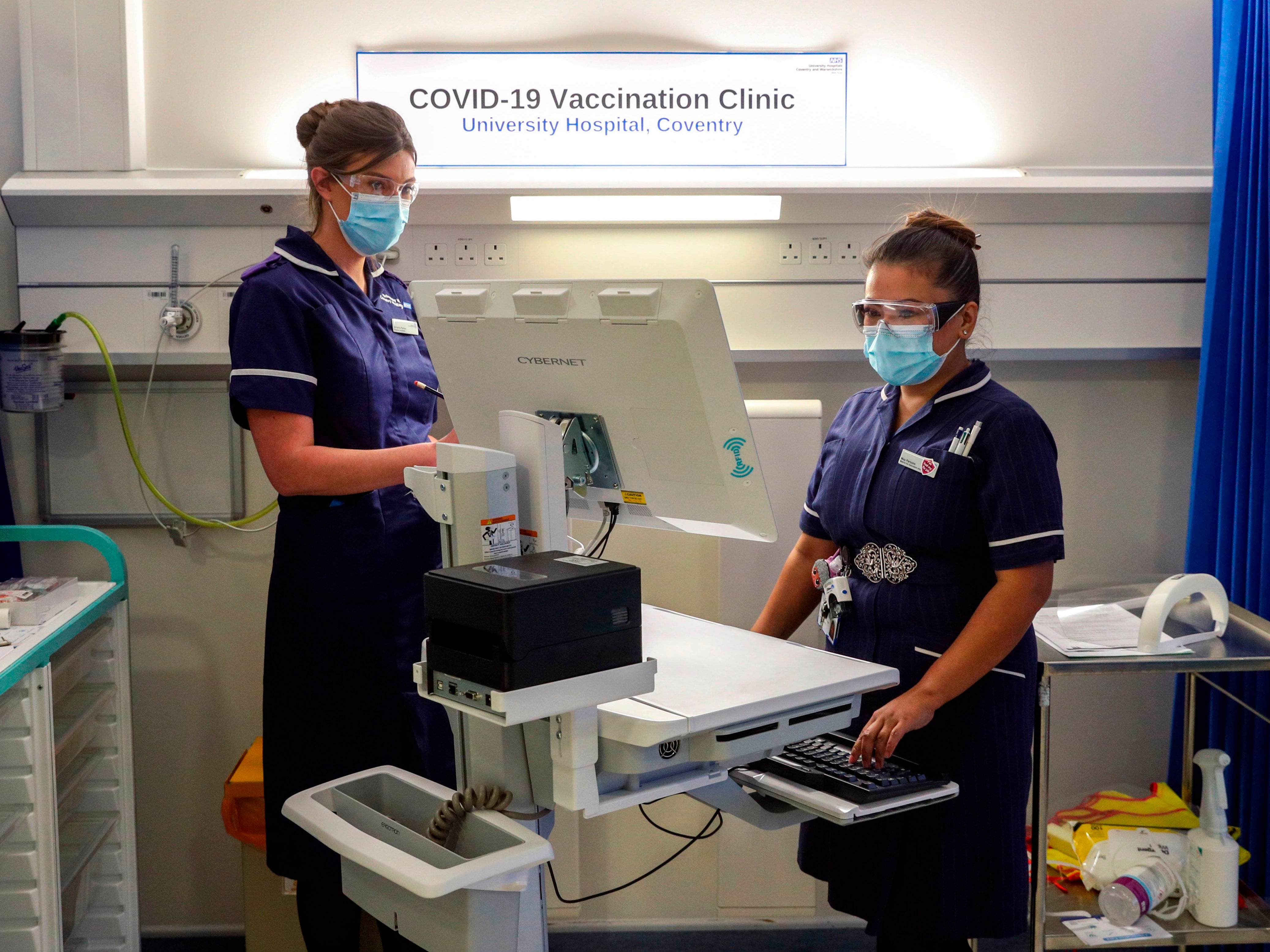 Wearing a protective face coverings to combat the spread of the coronavirus, Matron May Parsons (R) is assessed by Victoria Parker (L) during training in the Covid-19 Vaccination Clinic at the University Hospital in Coventry