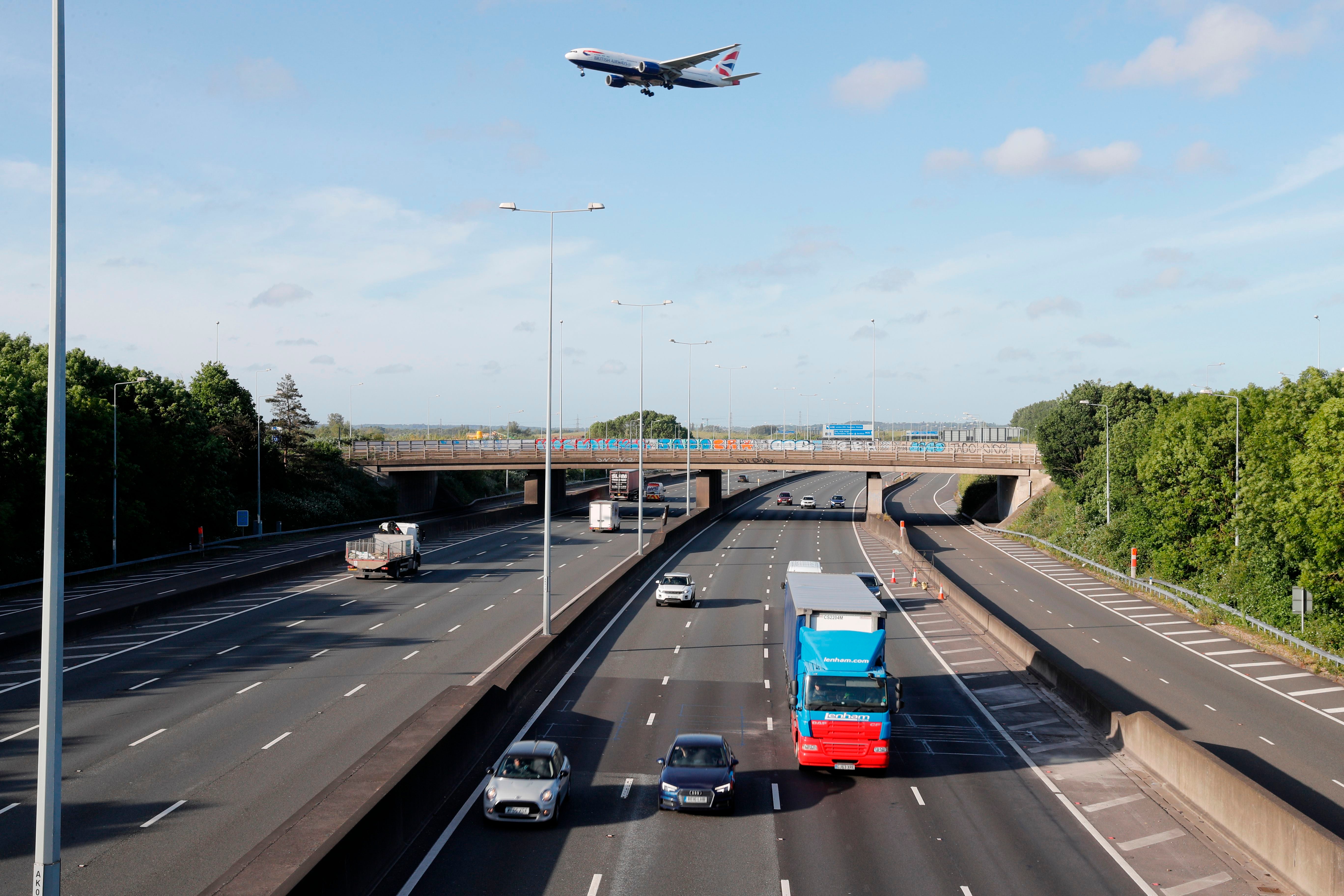 Traffic is seen on the M25 motorway as a plane flies overhead during the morning rush hour near Heathrow Airport in west of London on May 11, 2020.